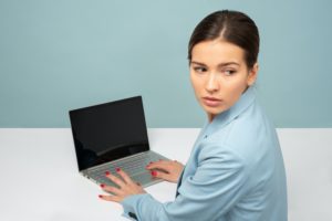 lady looking over shoulder while on laptop