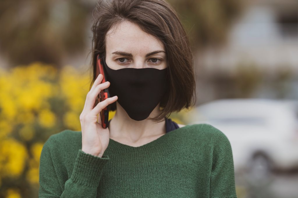 person wearing mask on cell phone call